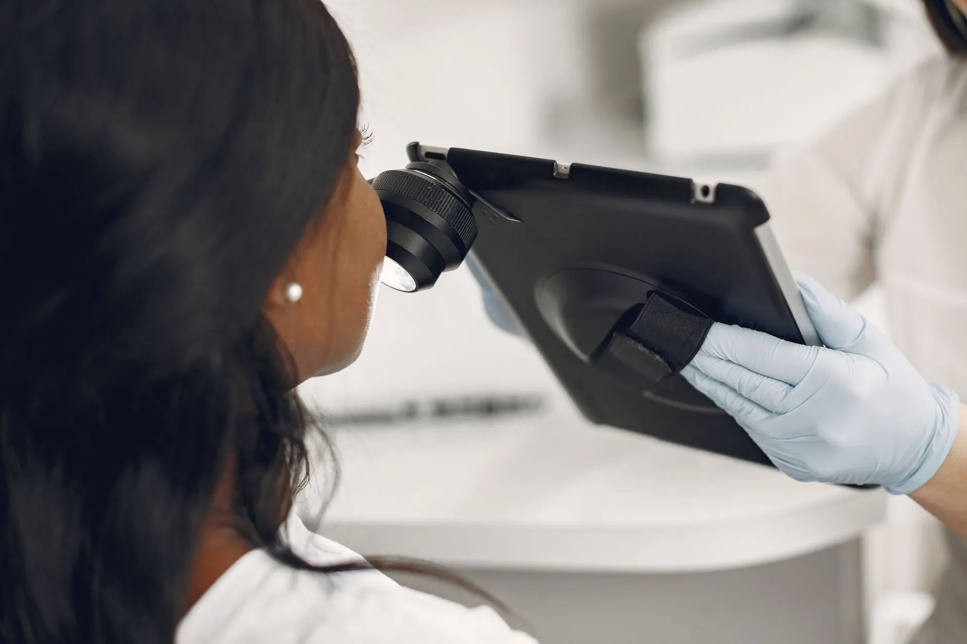 Exame da pele de uma paciente com dermatoscópio digital acoplado a um tablet